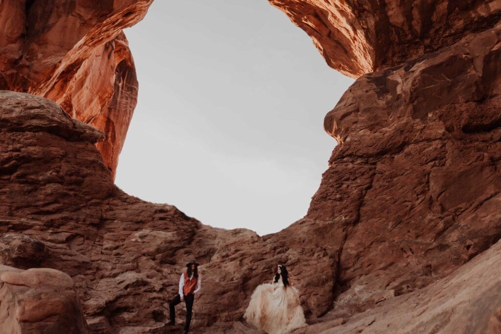 Boho western elopement couple at Arches National Park at the double arch at sunset